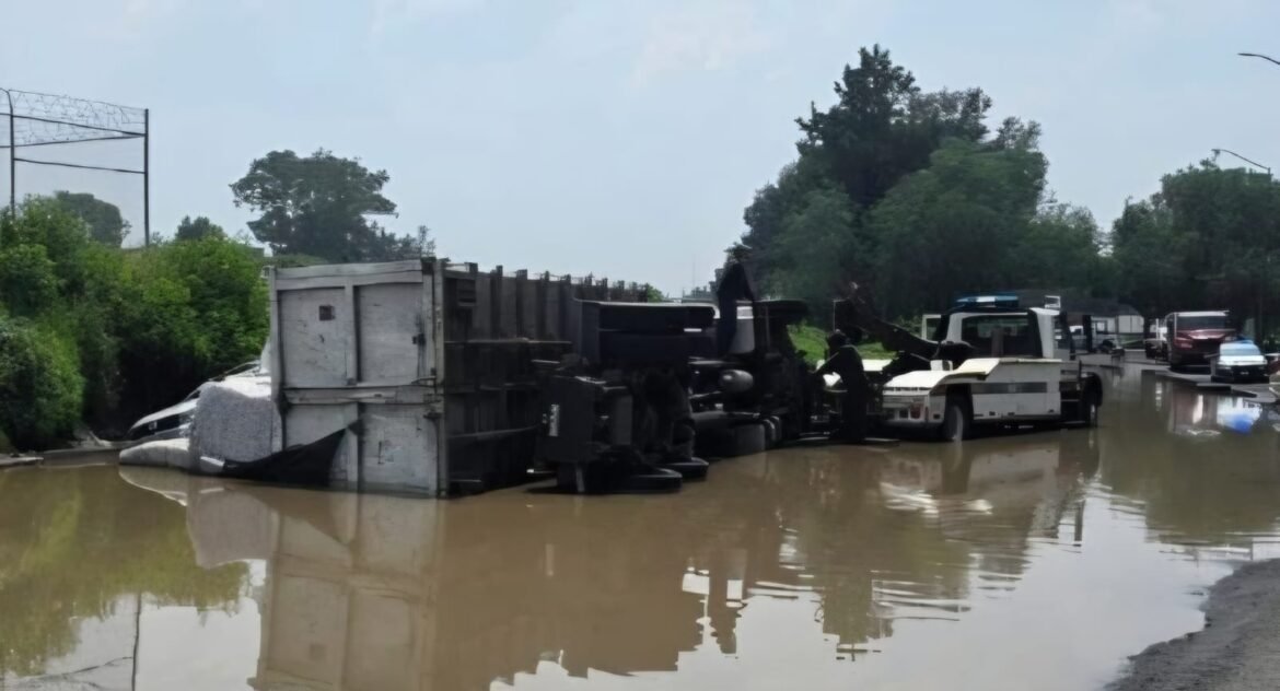 Volcadura de tráiler colapsa Periférico oriente tras caer en bache oculto por inundación